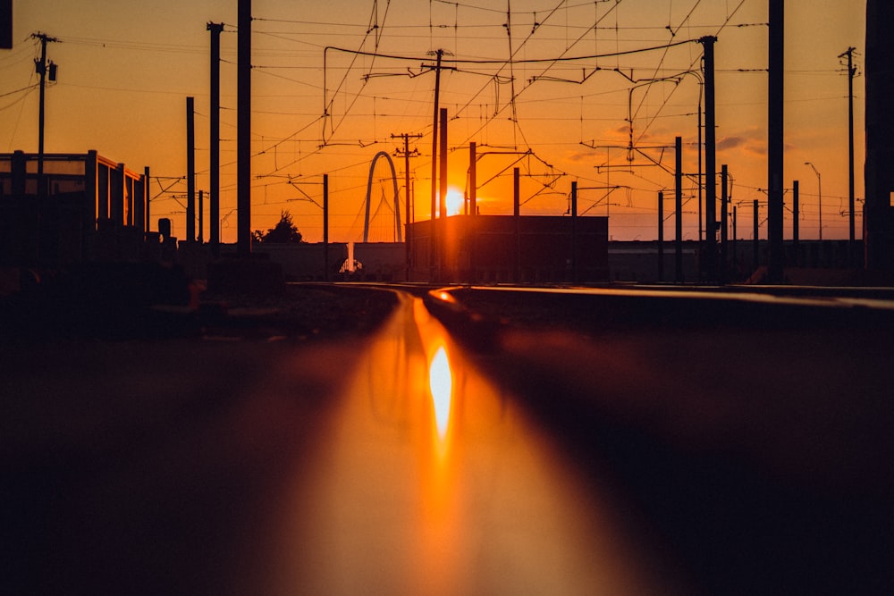 a train traveling down train tracks at sunset