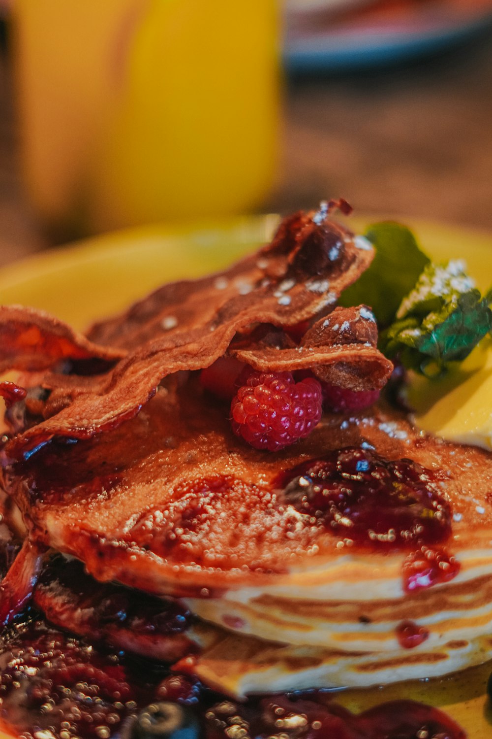 a yellow plate topped with pancakes covered in fruit