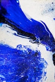 a blue and white abstract painting on a white background