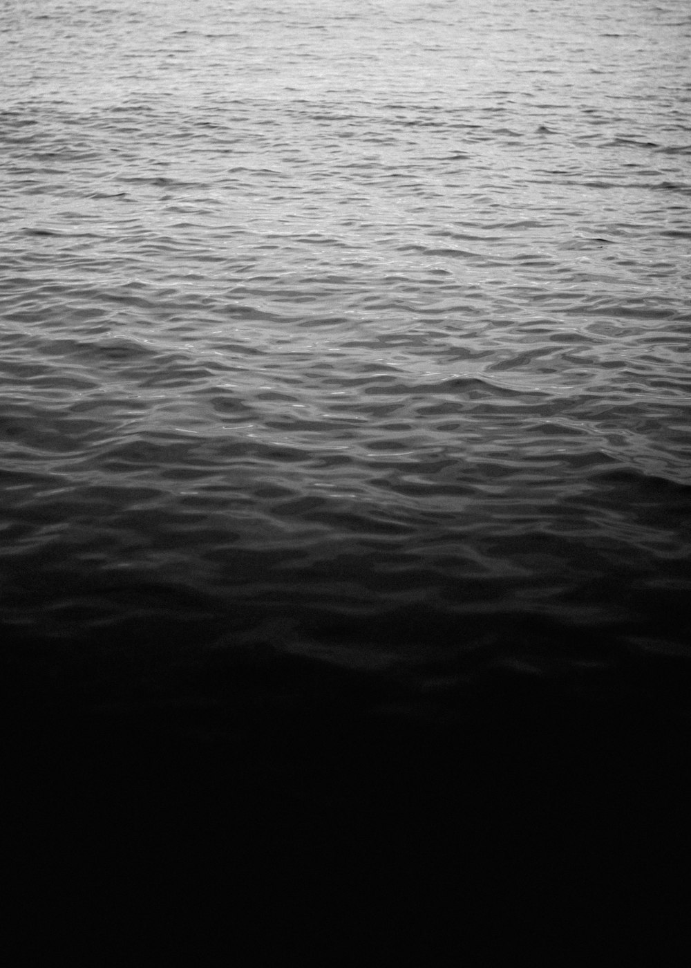 a large body of water with a boat in the distance