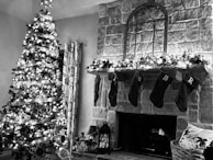 A beautifully painted fireplace mantel decorated with garlands and stockings.