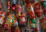 a group of colorful masks hanging on a wall