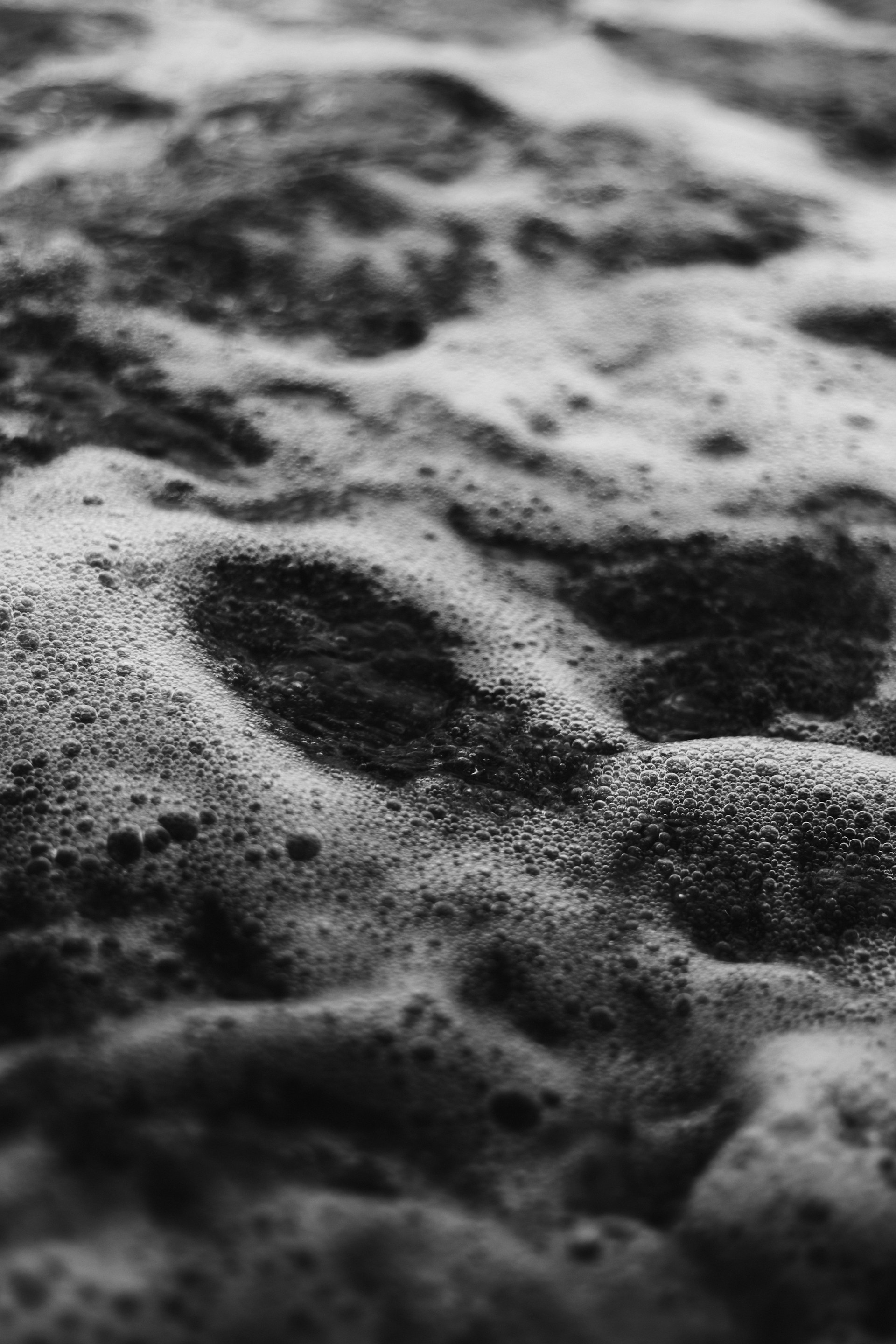 a black and white photo of sand and water
