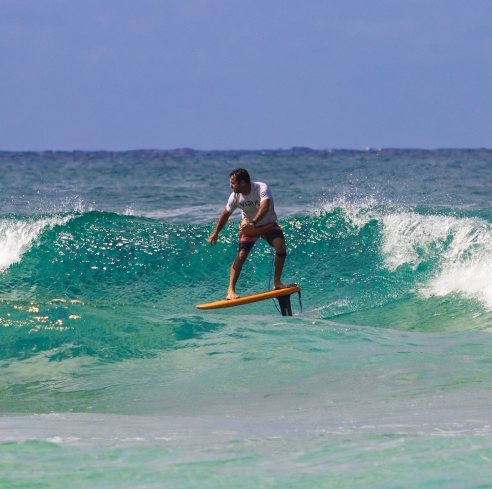 a man riding a wave on top of a surfboard