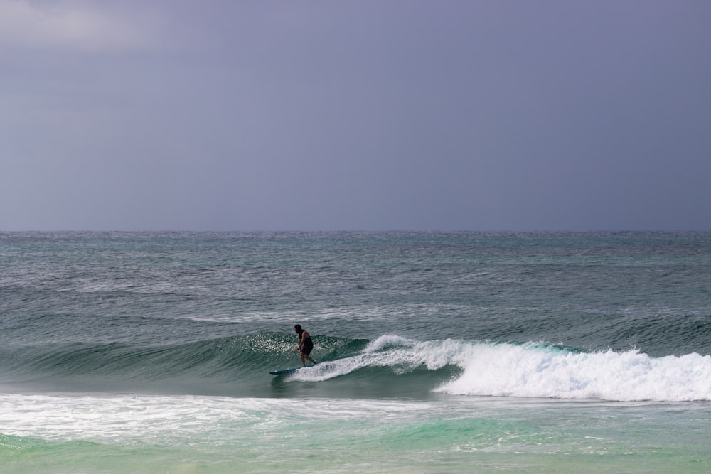 a person riding a wave on top of a surfboard