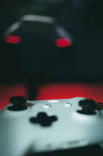 Close-up of hands on a sleek gaming controller with glowing dnxcoin.online logo in background.