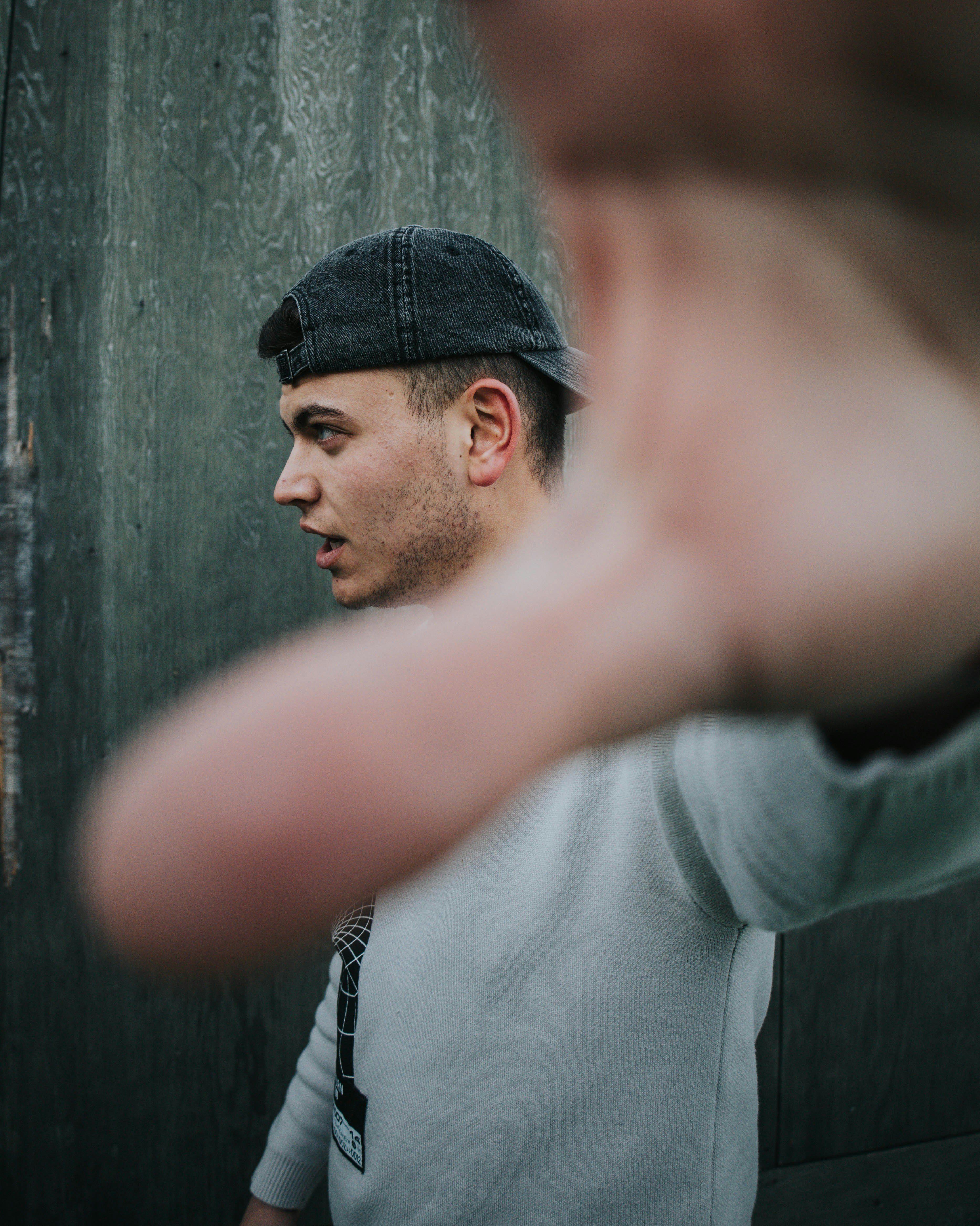 a man with a hat is making a hand gesture