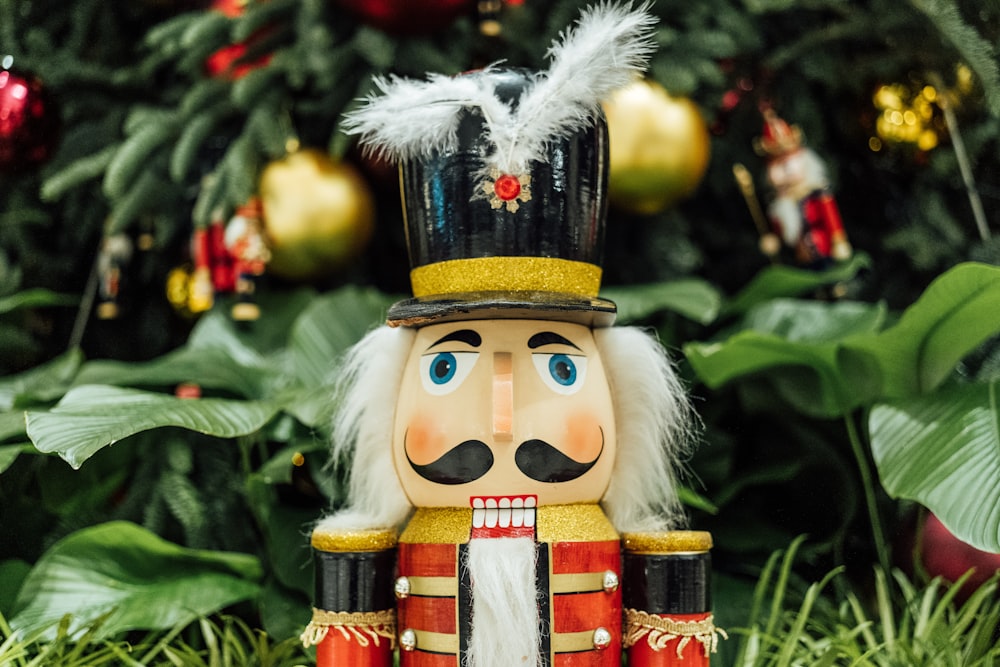 a nutcracker is standing in front of a christmas tree