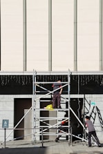 A team of professionals inspecting scaffolding equipment on-site for safety compliance.