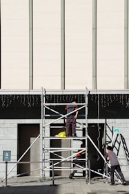 A team of professionals inspecting scaffolding equipment on-site for safety compliance.