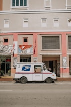 a mail truck parked in front of a building