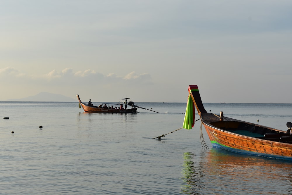 um par de barcos flutuando em cima de um corpo de água