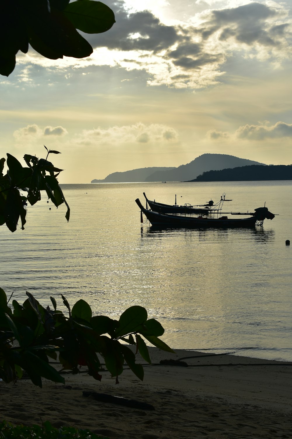 a boat sitting on top of a beach next to the ocean