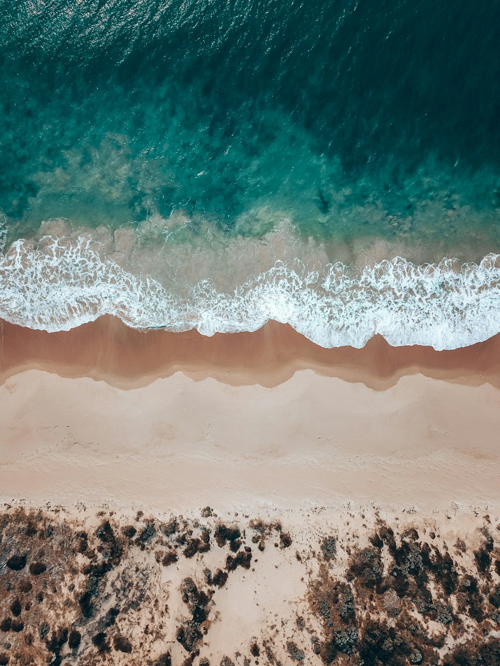 an aerial view of a sandy beach and ocean