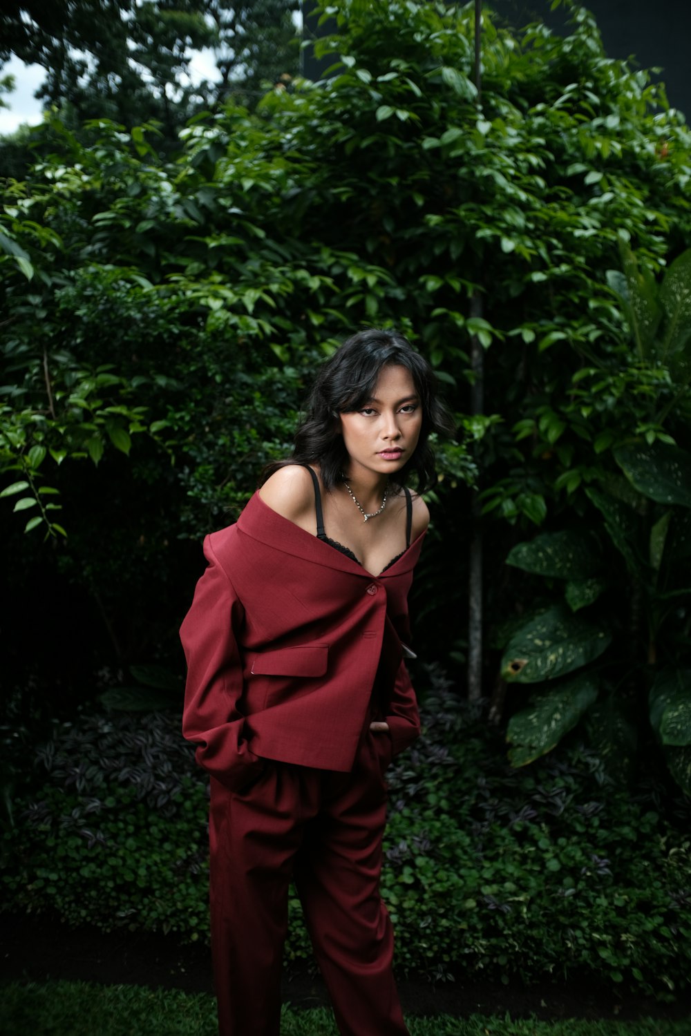 a woman standing in front of a lush green forest