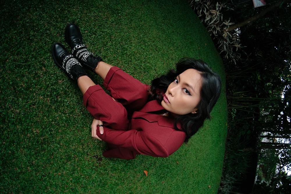 a woman laying on the grass with her legs crossed