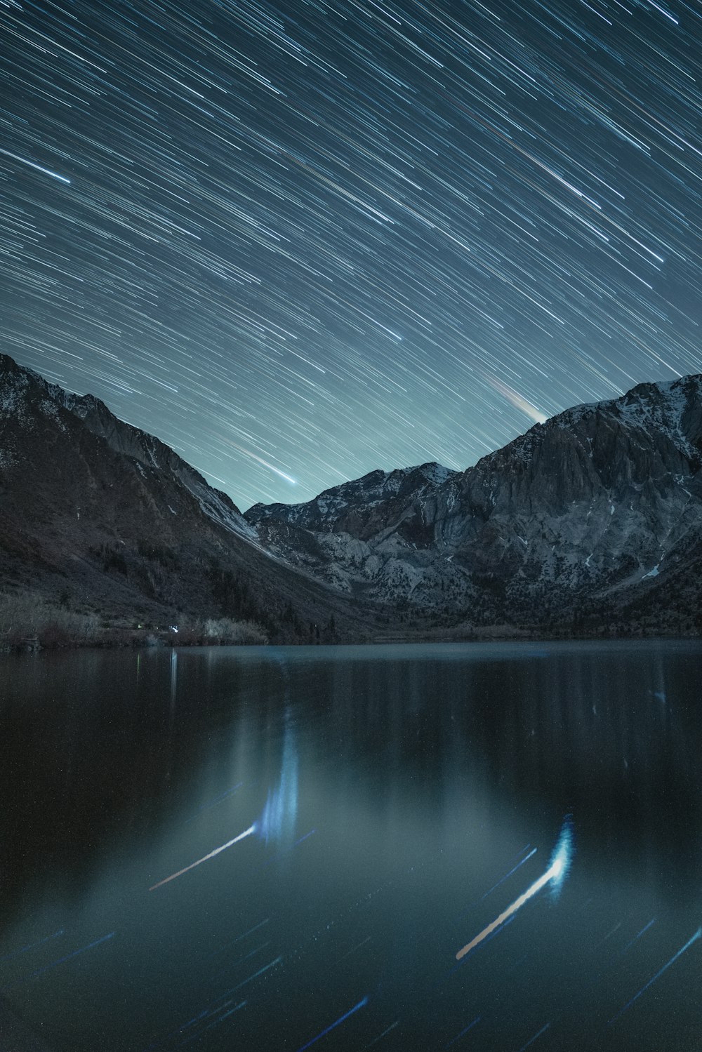 Il cielo notturno è illuminato su un lago di montagna