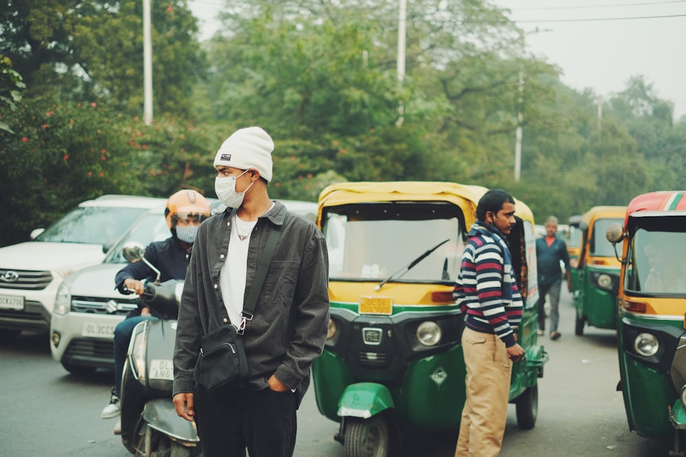 a man wearing a face mask standing in the middle of a street