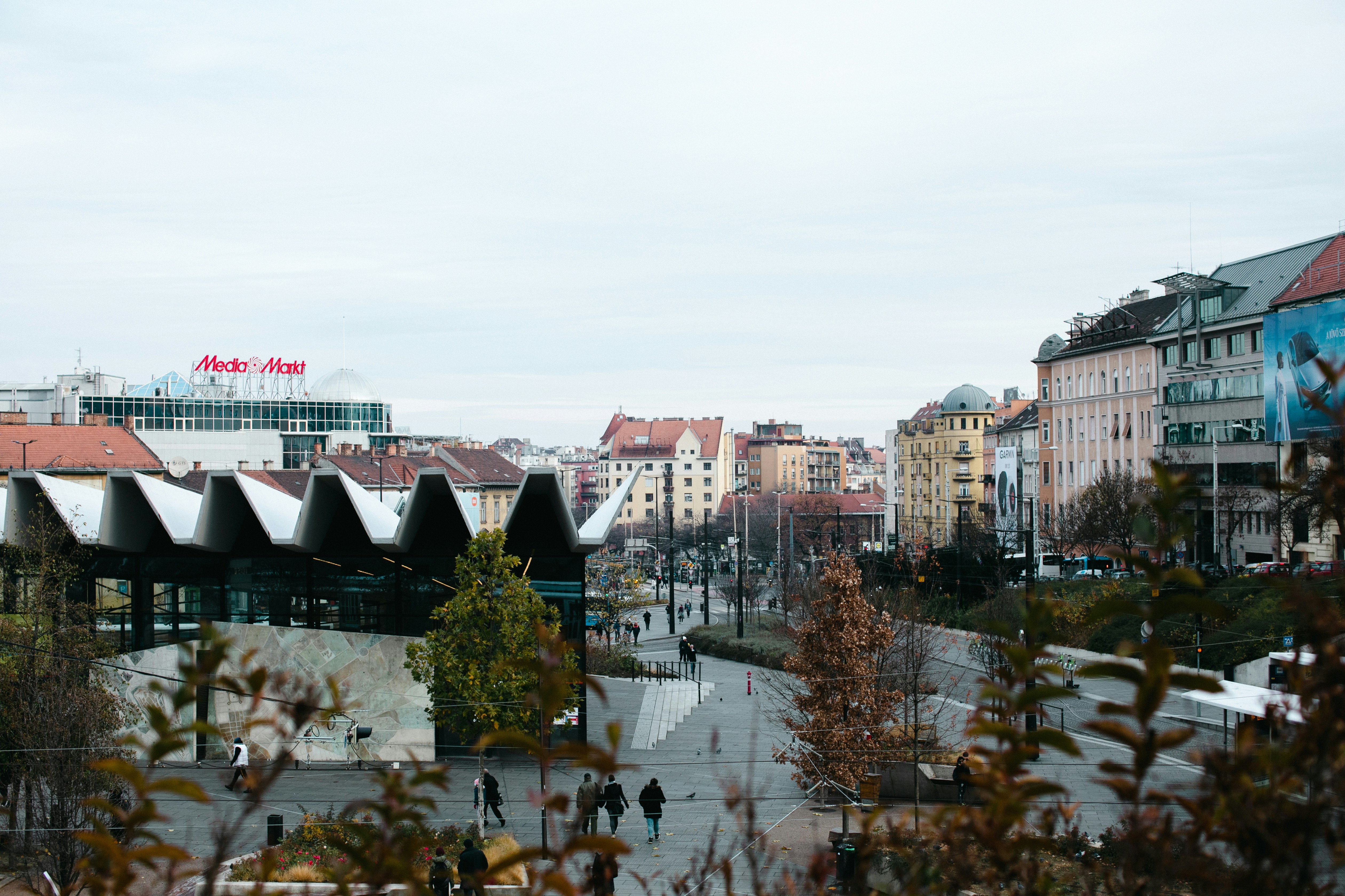 sekelompok orang berjalan di jalan di sebelah gedung-gedung tinggi