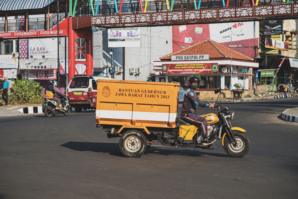 a man on a motorcycle driving down a street