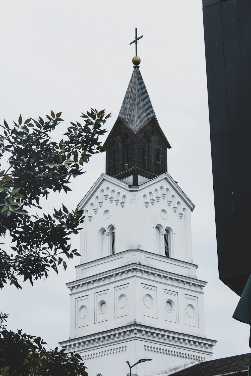 a tall white church steeple with a cross on top