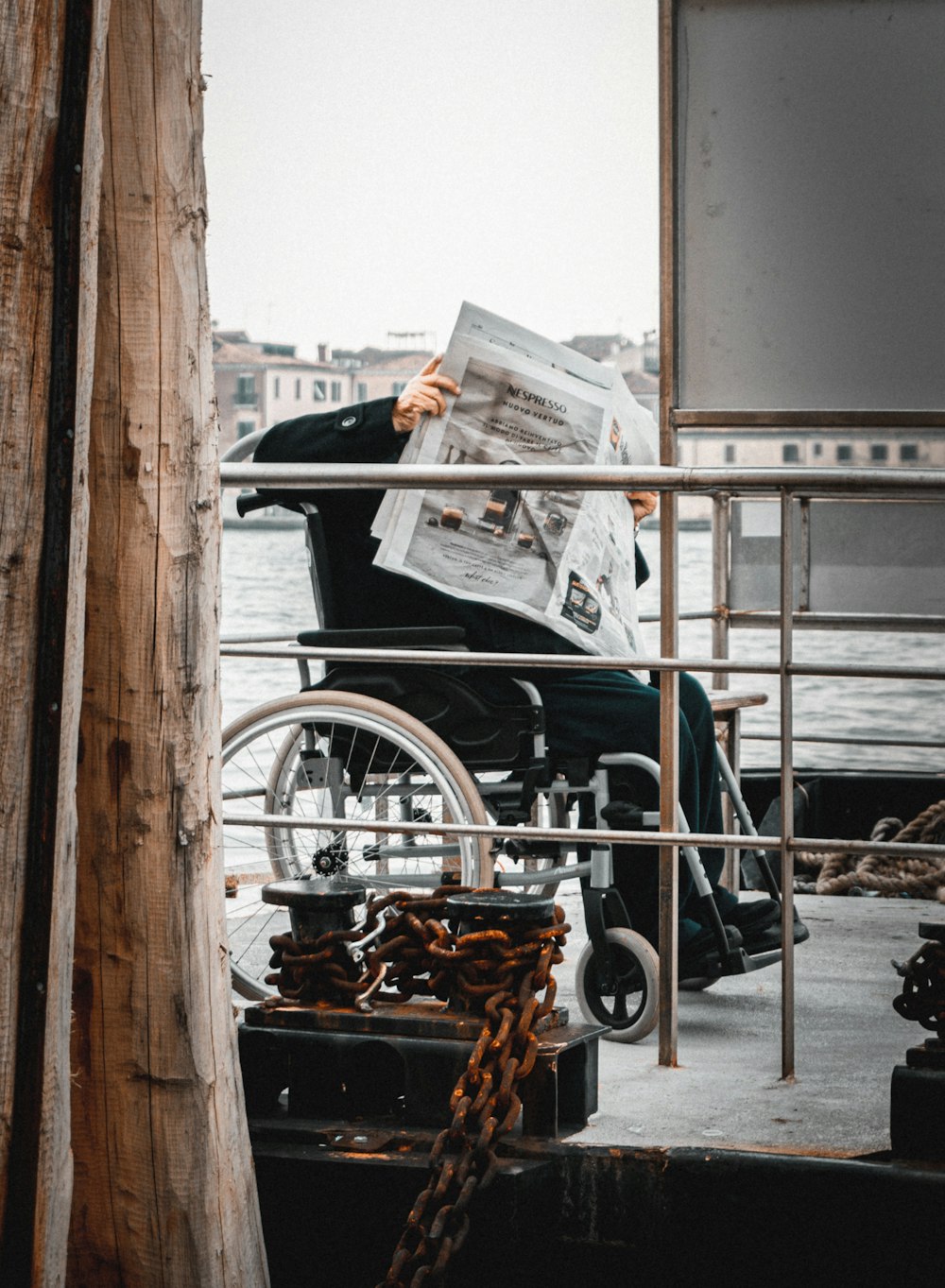 a man in a wheel chair reading a newspaper