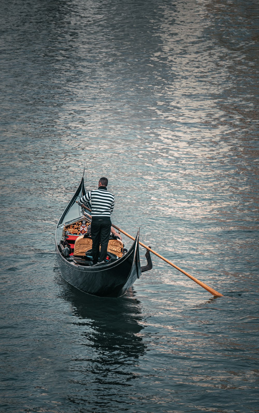 a man in a striped shirt is rowing a gondola