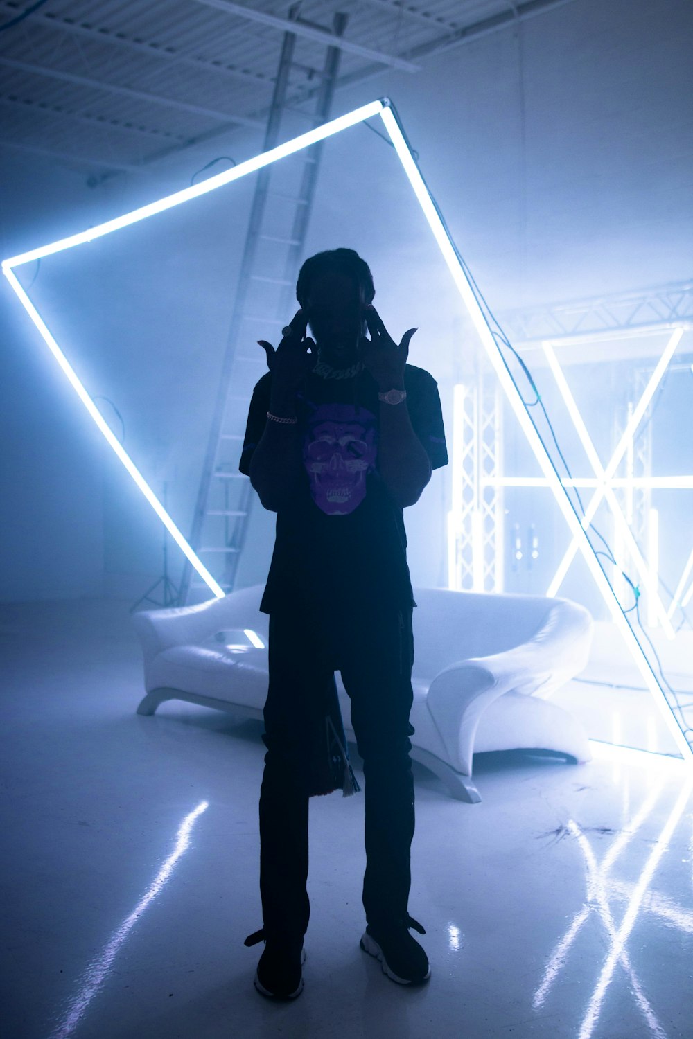 a person standing in a room with a neon light