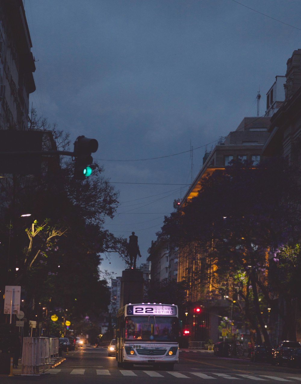 a city street at night with traffic lights and a bus