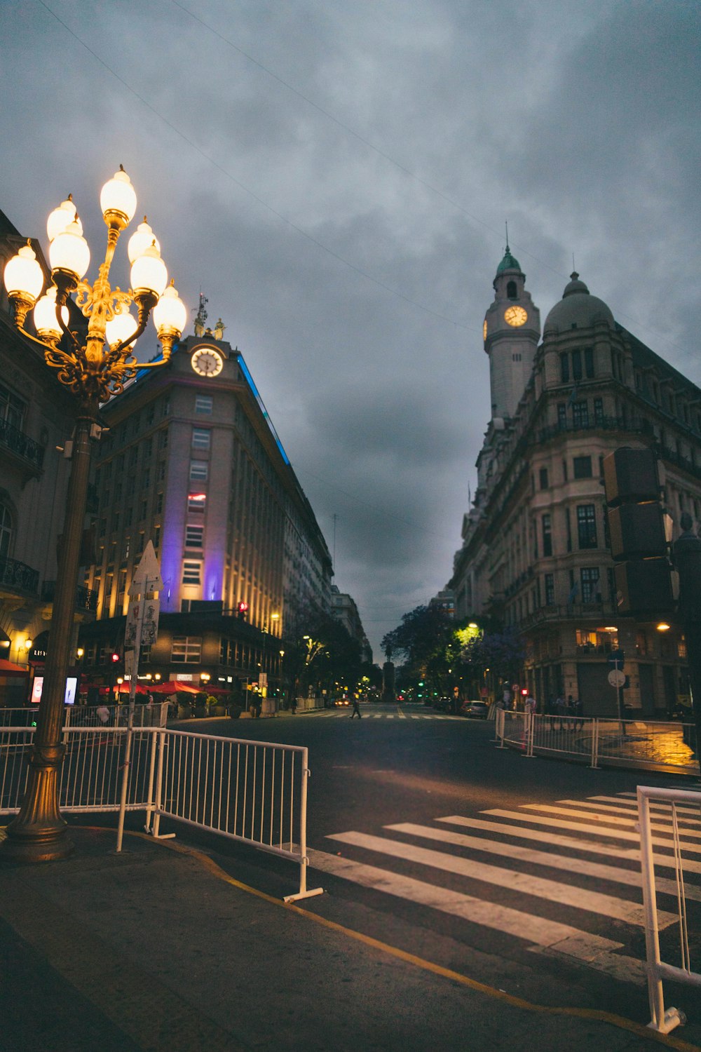 a city street at night with a clock tower in the background