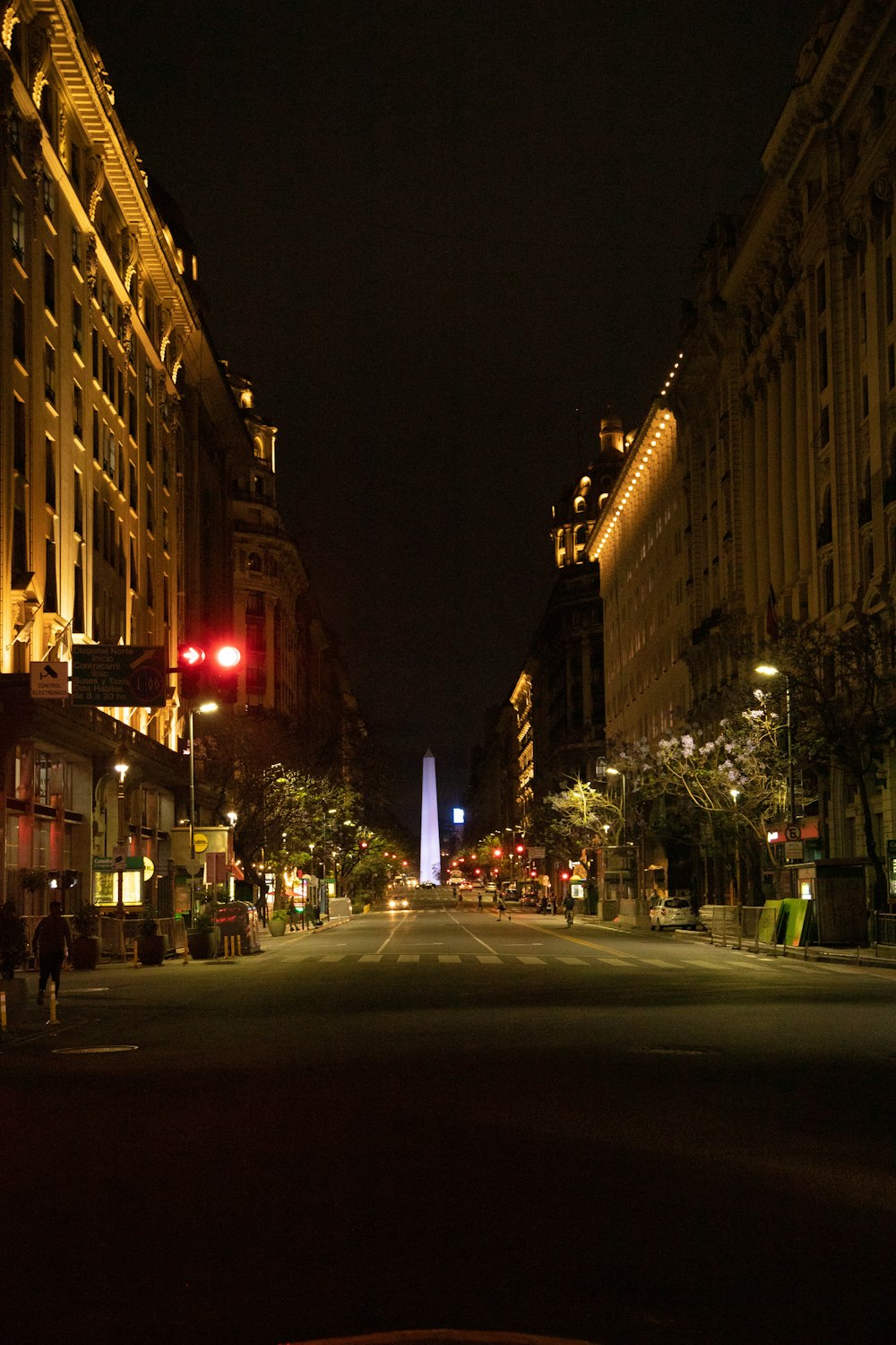 a city street at night with a red traffic light