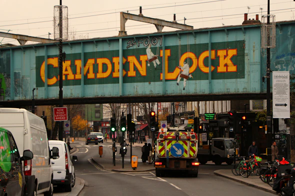 a truck driving under a bridge with a sign on it