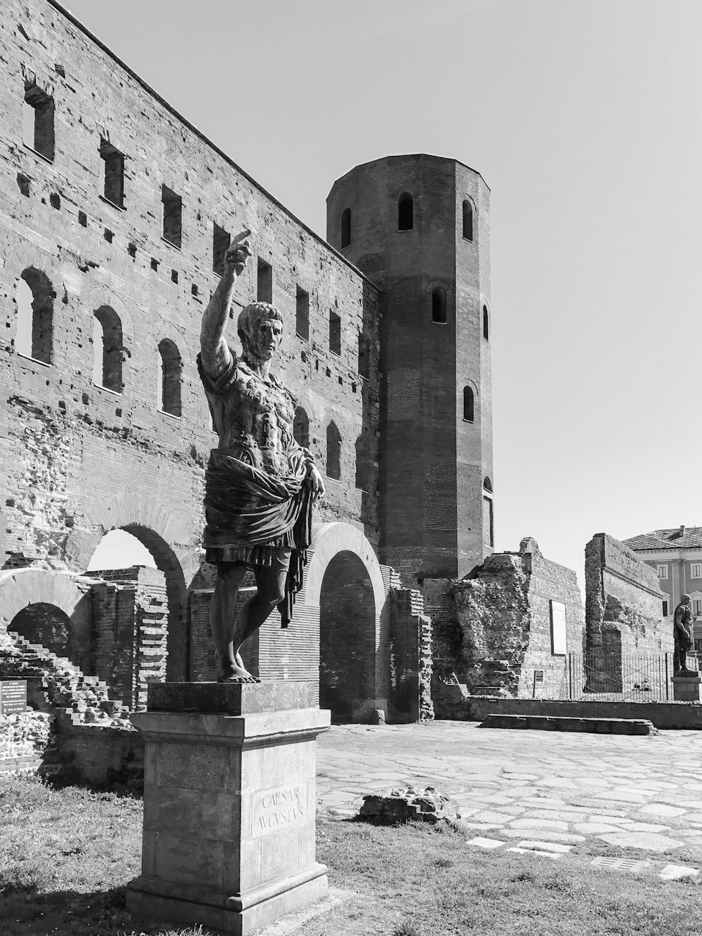 a black and white photo of a statue in front of a castle