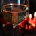 A close-up of a crystal wine glass catching the warm glow of candlelight on a polished wooden table.