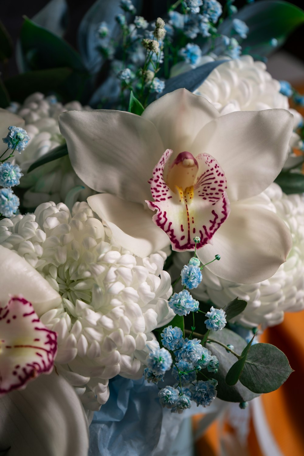 a bouquet of white and blue flowers in a vase