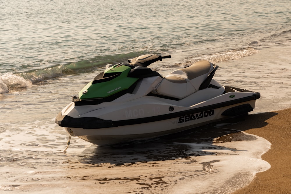 a green and white jet ski on the beach