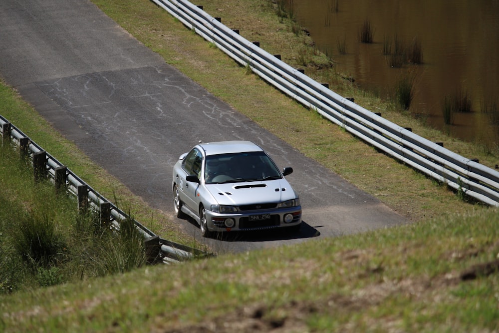 a white car driving down a winding road
