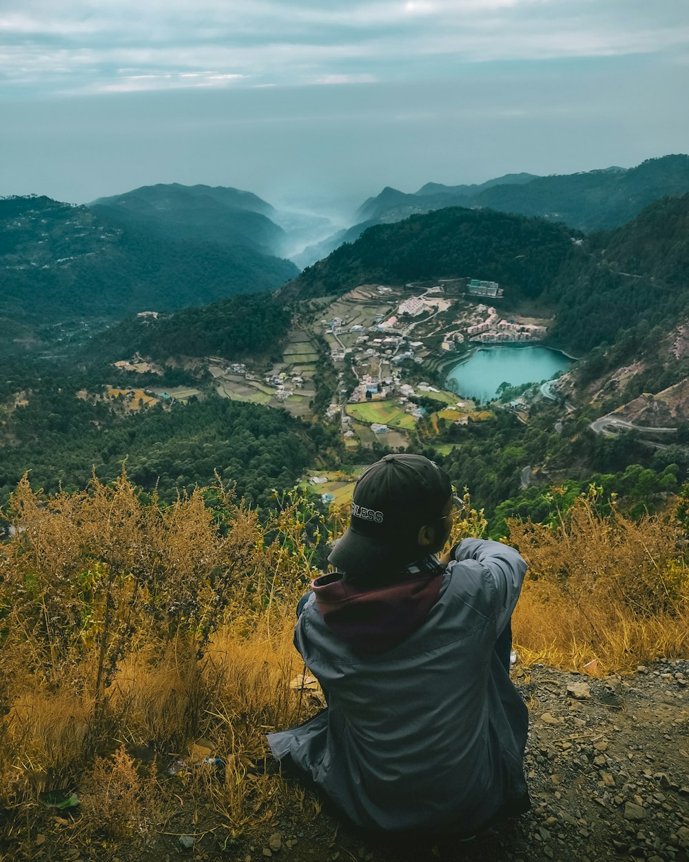 a person sitting on a hill overlooking a valley