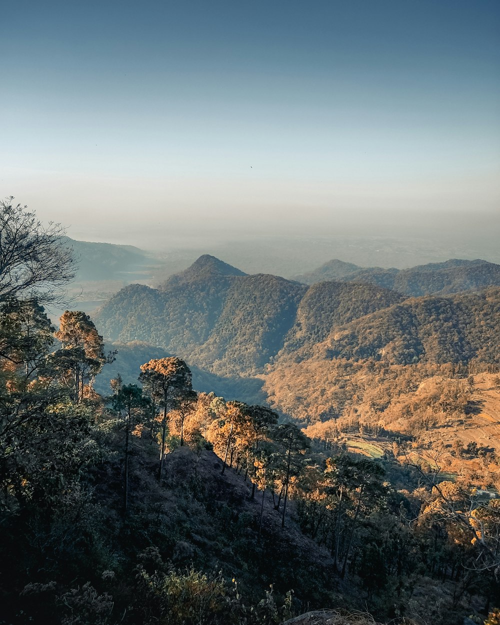 a view of a mountain range with trees and mountains in the background