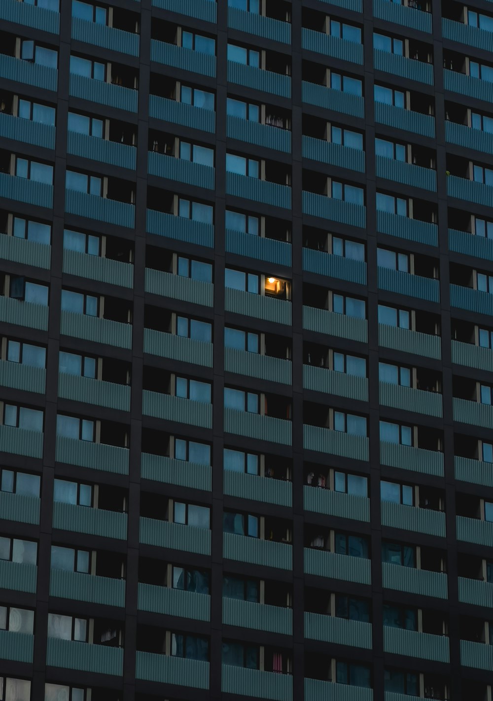 a tall building with lots of windows and a yellow light