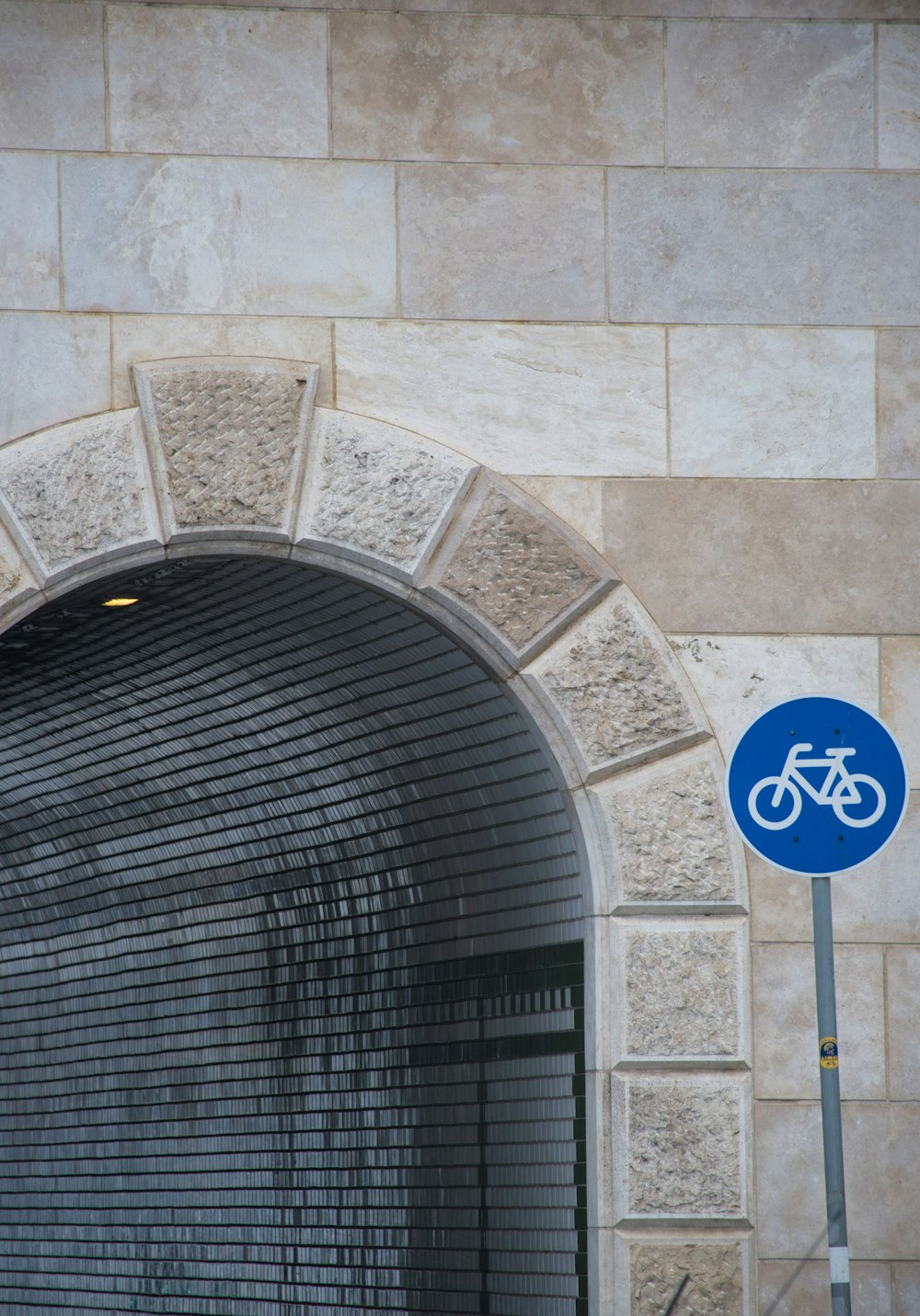 um sinal de bicicleta na frente de um arco de pedra