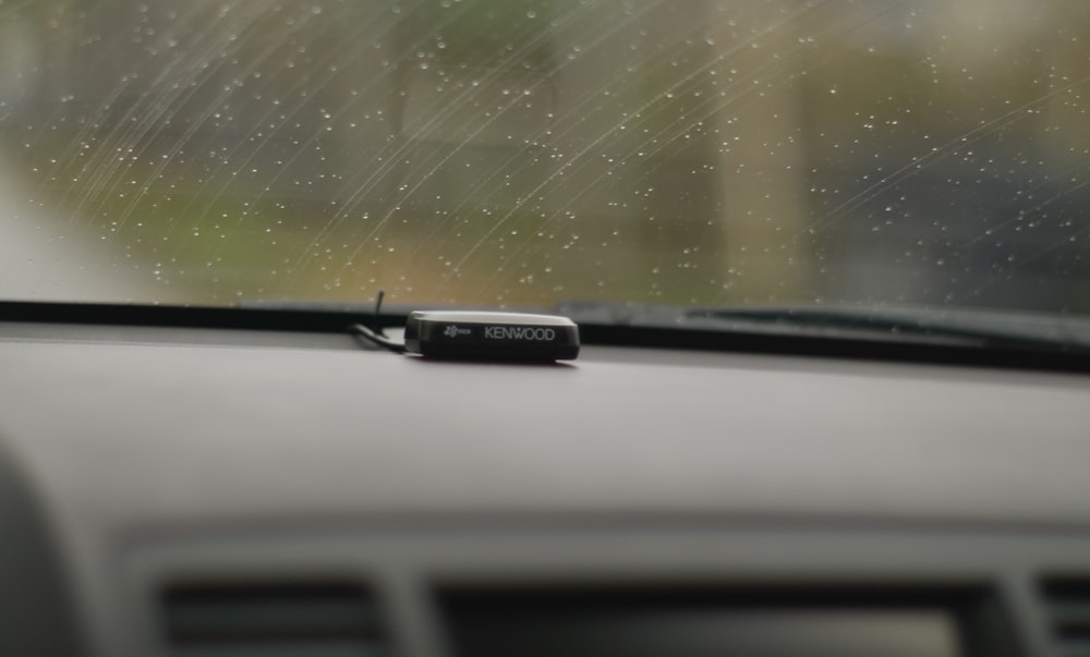 a close up of a car dashboard with rain coming down