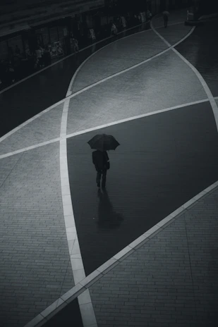 A colorful still from a short film showing a character walking through a rain-soaked street.