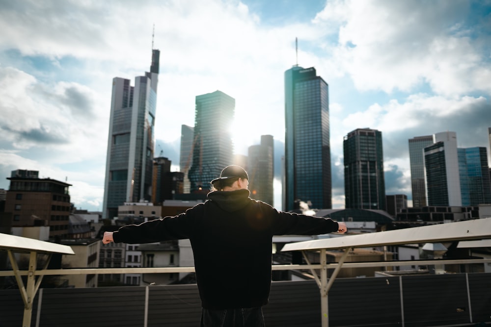 a man standing on top of a balcony next to a fence