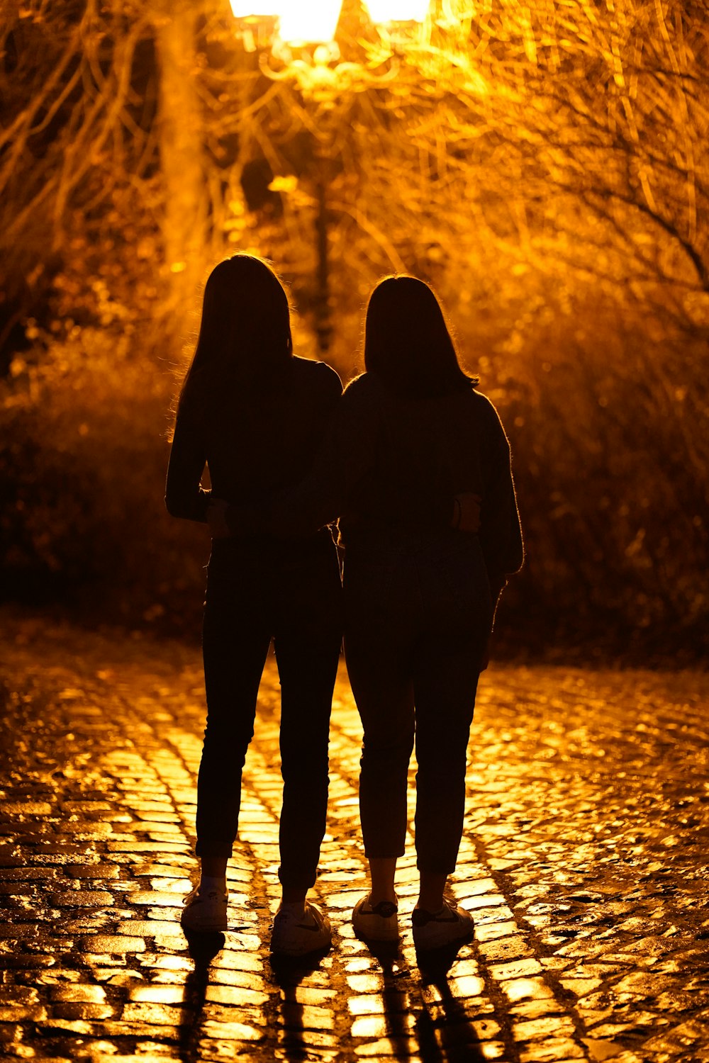 two people walking down a street at night