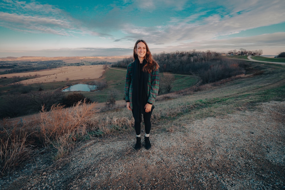 a woman standing on top of a dirt road