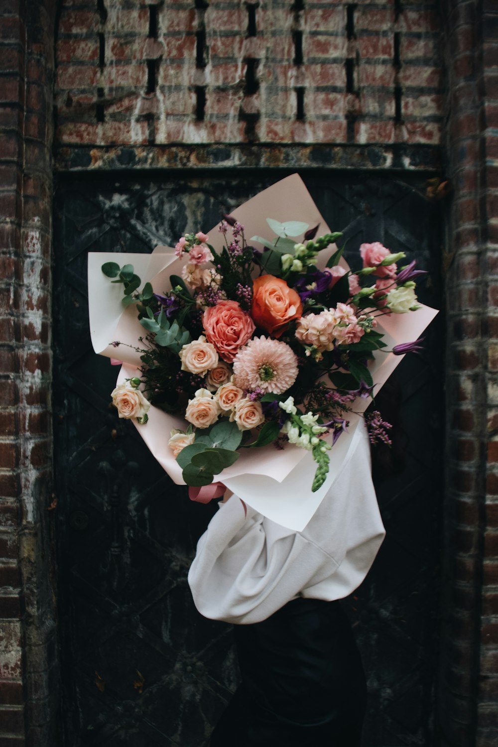 une personne tenant un bouquet de fleurs dans ses mains