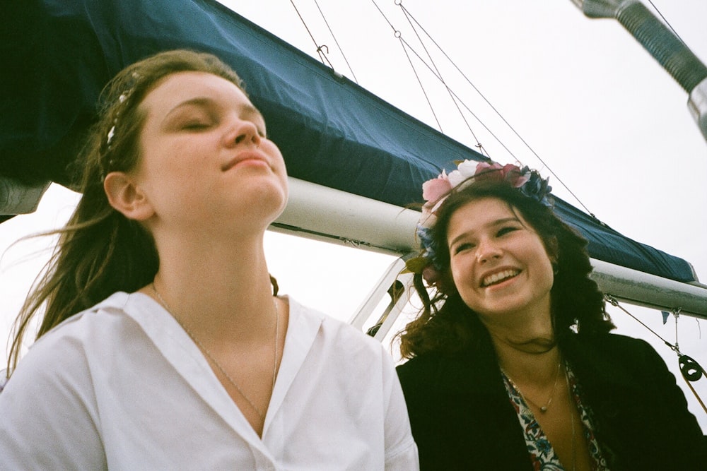 two women sitting on a boat looking up at the sky