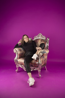 portrait photography,how to photograph ig: pgh_foto; a woman sitting on a chair with a purple background