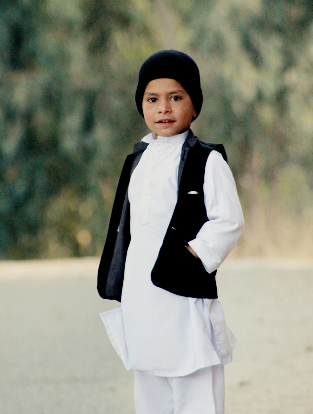 a young boy dressed in white and black